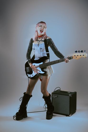 Energetic female musician playing bass guitar with passion.