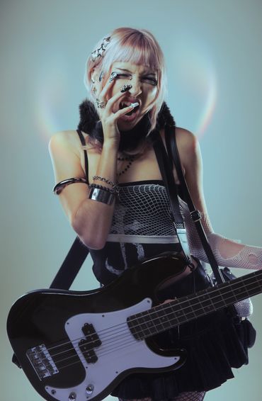 Young woman with a bass guitar and punk-inspired style.