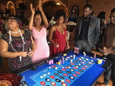 Amherst Casino Events' roulette table with excited guests at a 1920's theme casino night party.