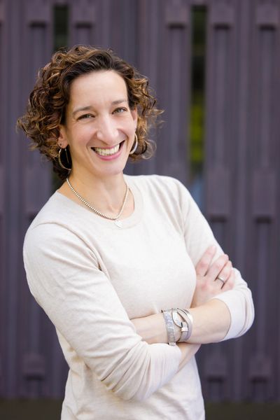 Rabbi Rochelle standing with her arms crossed and a big smile