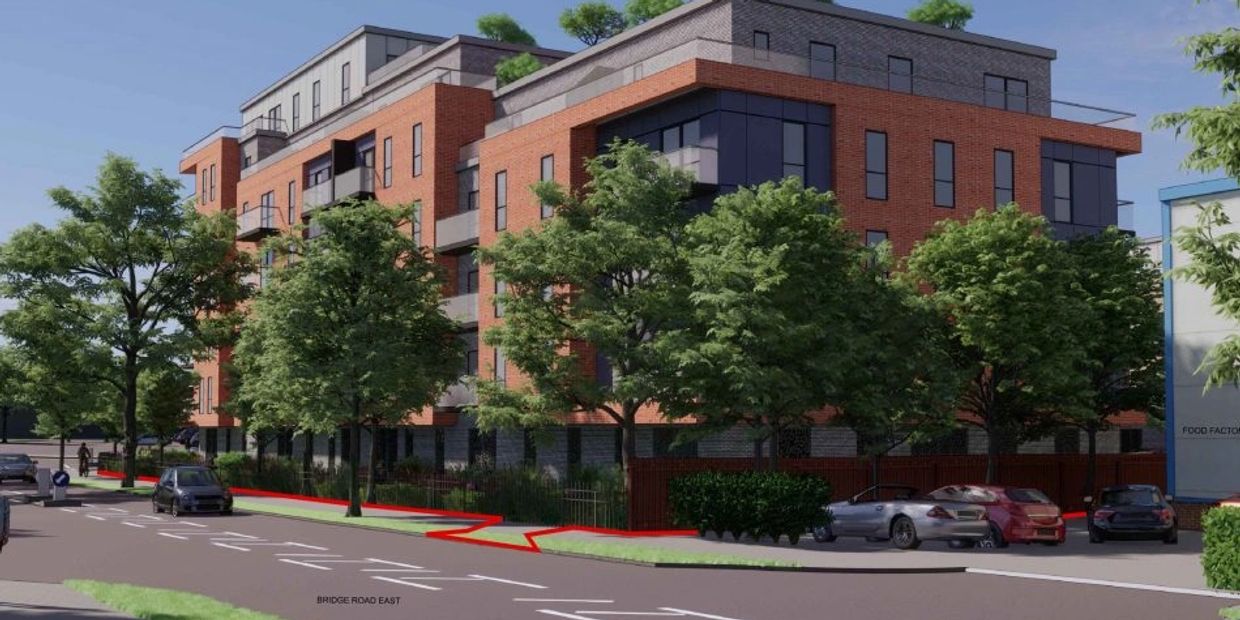 Modern brick apartment building with trees and parked cars.