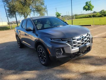 A sleek, gray Hyundai pickup truck parked outdoors on a sunny day.