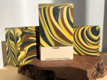Soap bar called Tiger. The bars have a combination of yellow, maroon, and dark green stripes.