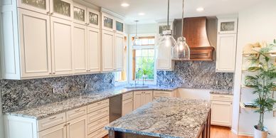 Bright kitchen with granite countertops and white cabinetry.
