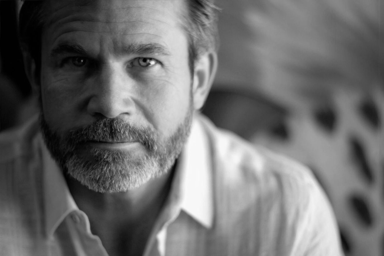 Black and white close-up portrait of a man with a beard.