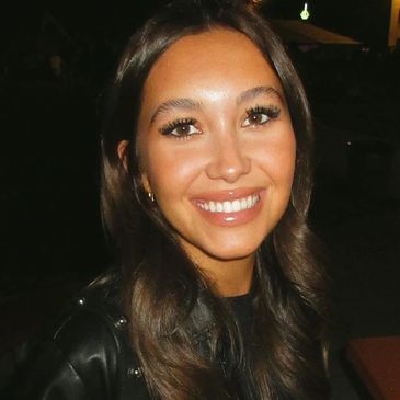 A young woman smiling at night.