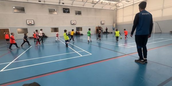 Children participating in an engaging indoor multi-sport session led by KBMultiSport coaches, 
