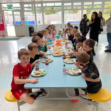 Children enjoying a group meal during a KBMultiSport event, highlighting community building, 