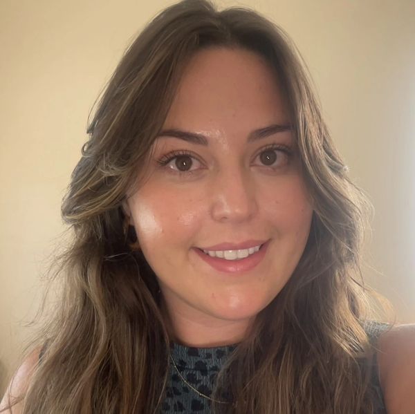Young woman smiling with long brown hair.