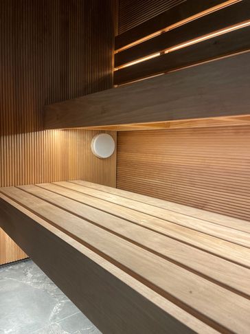 Modern wooden sauna interior with bench and soft lighting.