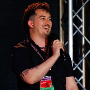 Man speaking into a microphone at an event.