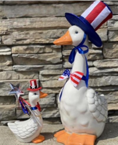 Two decorative ducks dressed in patriotic red, white, and blue hats and accessories.