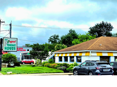 Exterior view of The Original Pancake House with parked cars and a cloudy sky.