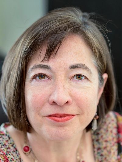 Close-up portrait of a woman with short brown hair and red lipstick.