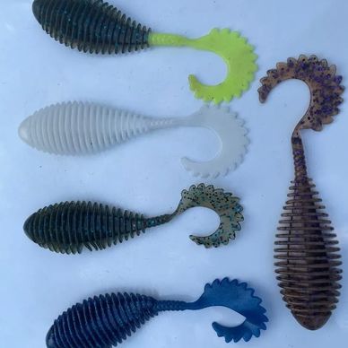 Five soft plastic fishing lures in various colors and shapes.