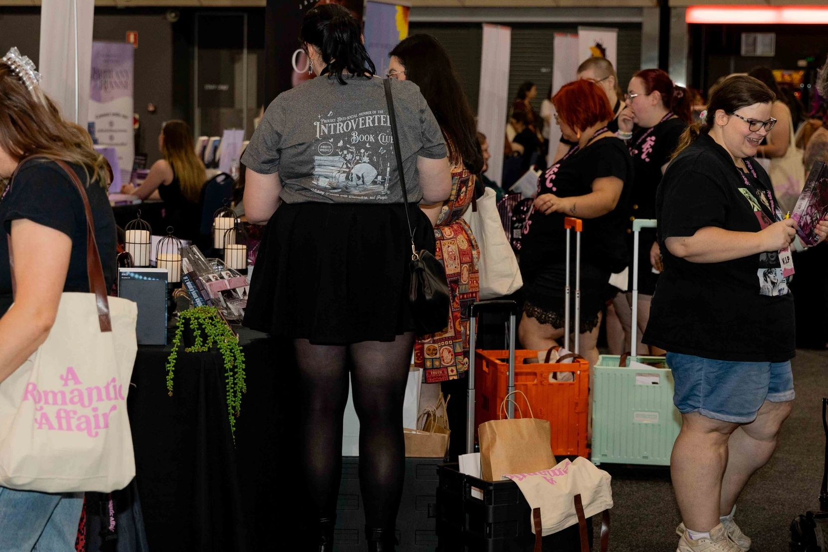People browsing and socializing at a busy indoor market or convention.
