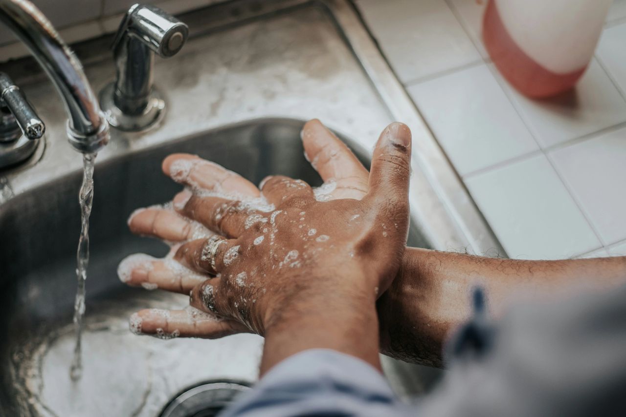 a pair of soapy hands over a sink a pair of soapy hands over a sink