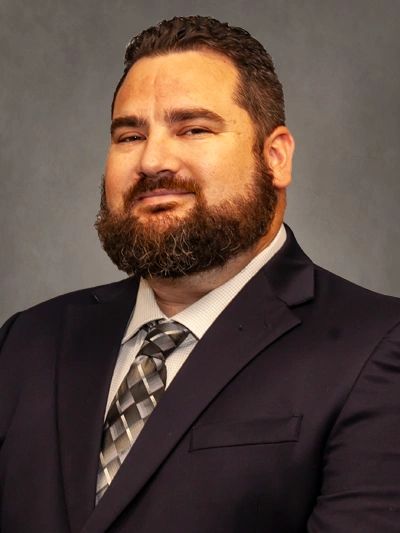 Confident man with beard wearing a suit and tie.