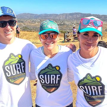 Women runners at finish line of ultra run, wearing customized shirts by Running Awards & Apparel.