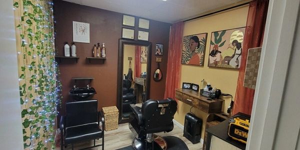 Picture of the salon suite with chair, mirror brown walls, and wash bowl for hair services.