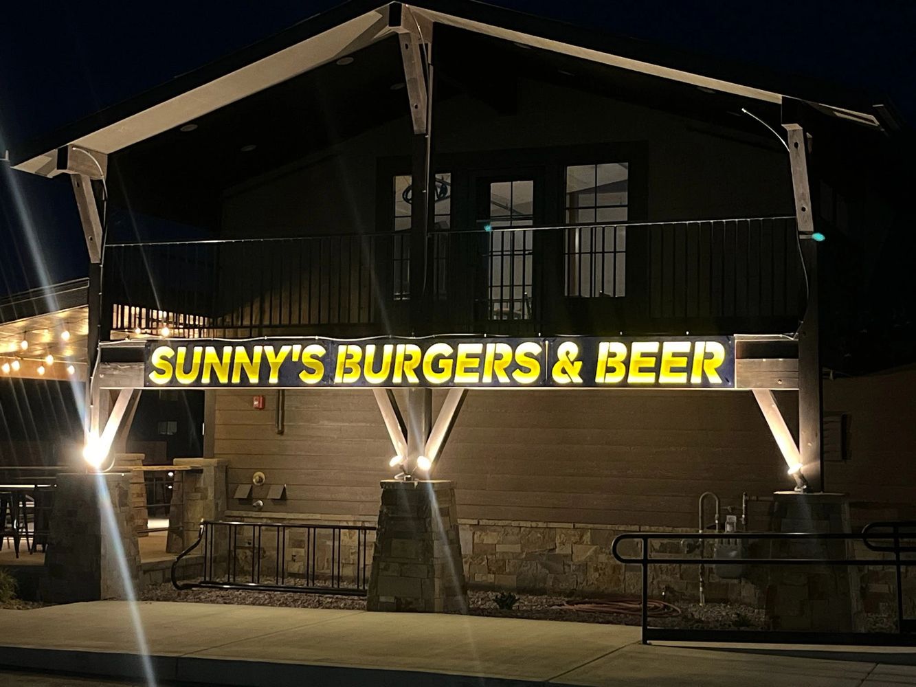 Illuminated sign of Sunny's Burgers & Beer at night.