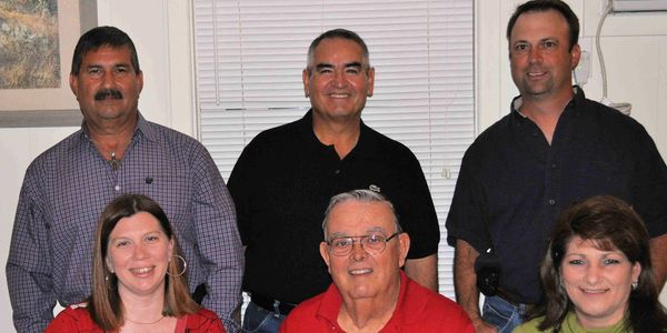 Group of six adults posing indoors.