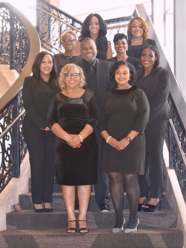 Group of smiling professionals posing on stairs.