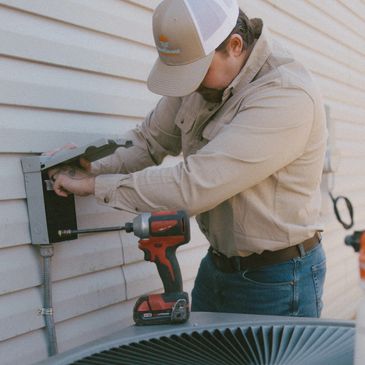 Buford, GA. Professional HVAC technician performing maintenance on an air conditioning unit