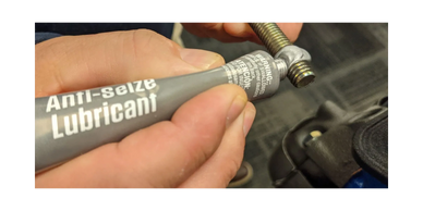 person using anti-seize lubricant on screw