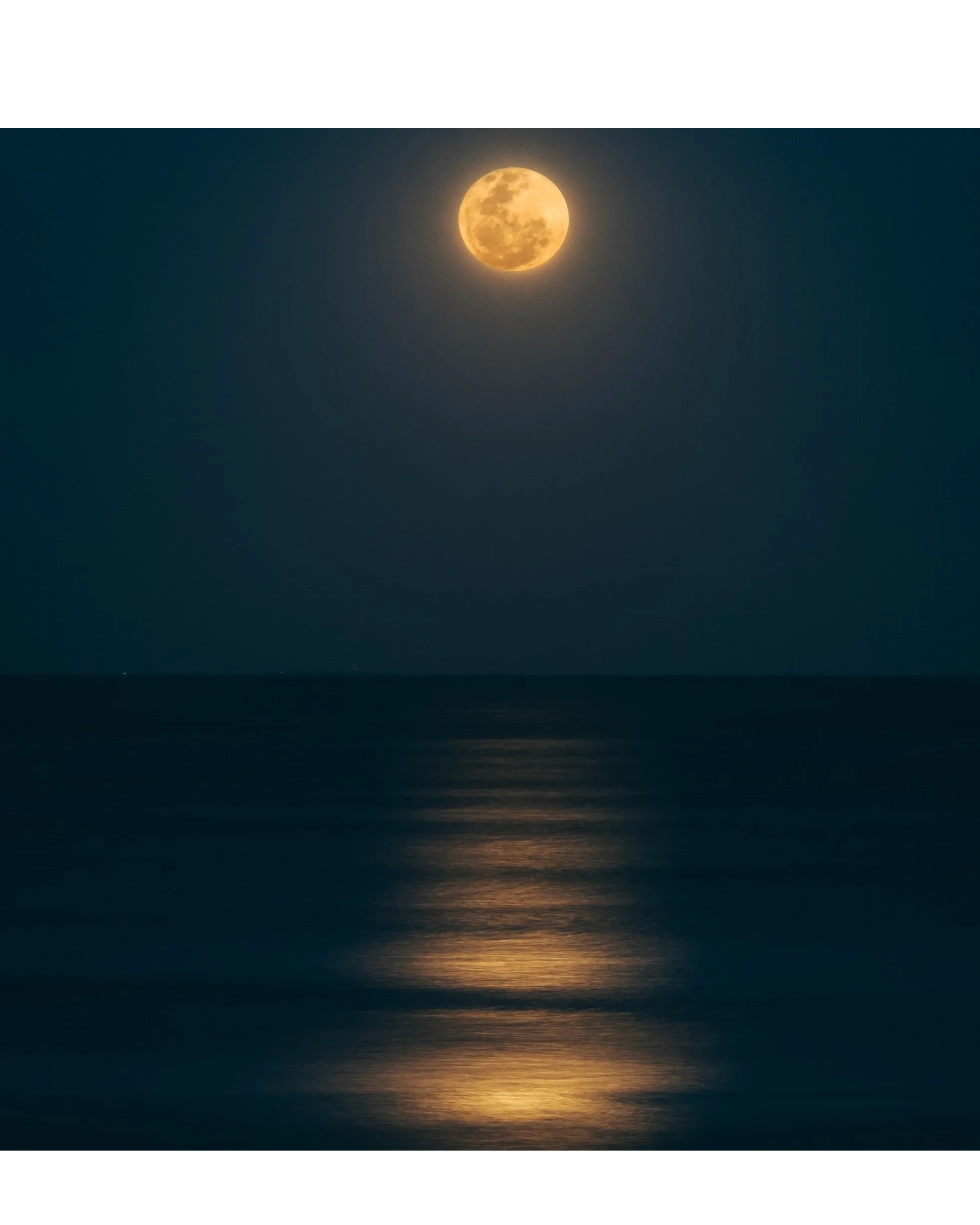 The full moon illuminating the sea at night time, a symbol and expression of the feminine cycles.