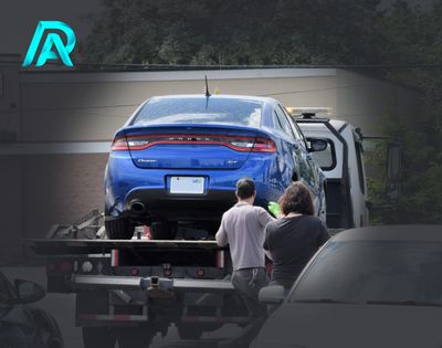 Blue car being towed on a flatbed truck.
