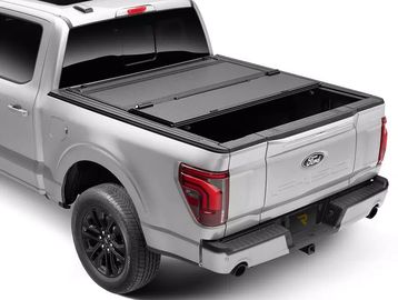 Silver pickup truck with a black retractable tonneau cover on the bed.
