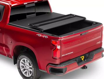 Red Chevrolet Silverado truck with a black tonneau cover on the bed.