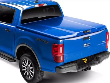 Blue Ford pickup truck with a hard tonneau cover on the bed.