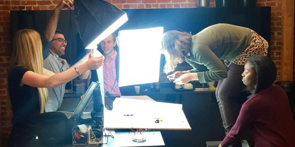 Team collaborating on a photoshoot with bright lighting indoors.