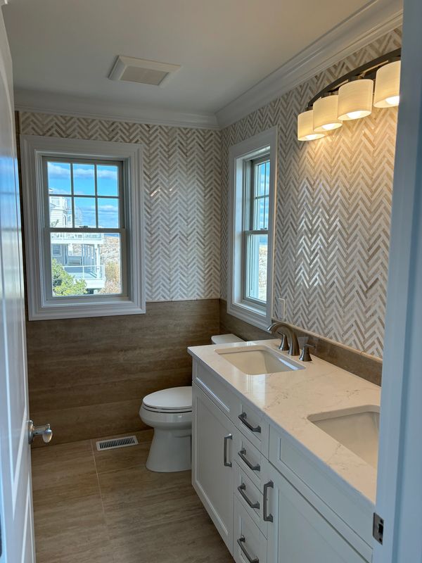 Bathroom remodel large format tile lower wall with marble mosaic tile upper