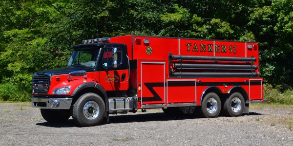 Red fire tanker truck parked outdoors.