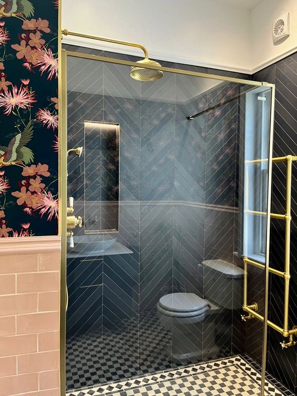 traditional navy blue chevron tiled bathroom with blue wallpaper and pink picture rail