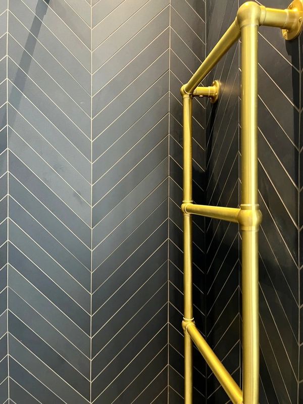 brass towel rail, blue chevron tiled wetroom walls