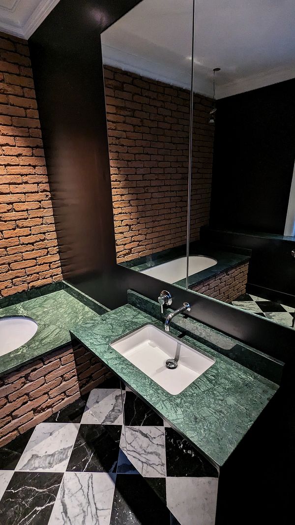 Marble checker board tiled floor, guatemala green marble bathtop, brick style wall, mirror cabinet
