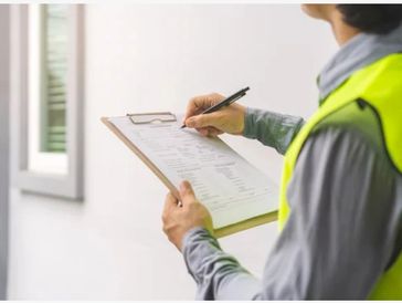 Electrician performing an inspection holding clip board