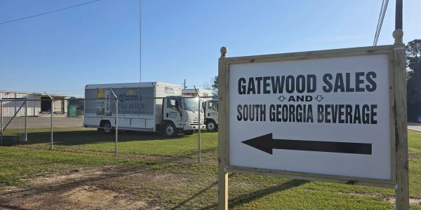 Sign directing to Gatewood Sales and South Georgia Beverage with trucks in the background.