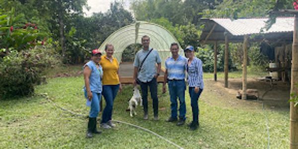 Cinco personas en un jardín con un perro.