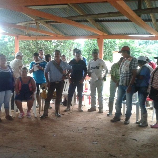 Personas reunidas bajo una estructura techada en área rural.