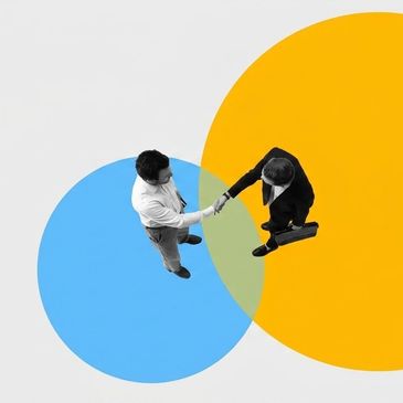 Two professionals shaking hands over overlapping blue and yellow circles.