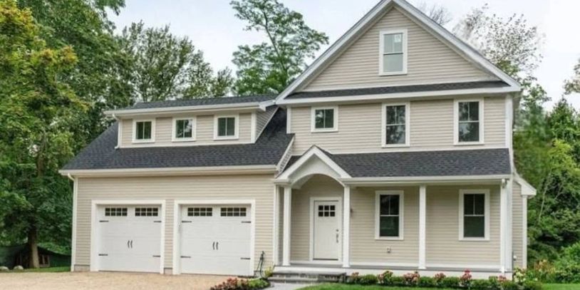 Modern two-story house with beige siding and double garage.