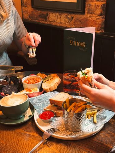 People enjoying a cozy meal with drinks and sandwiches at a rustic restaurant.