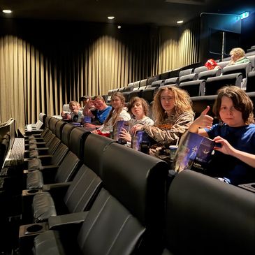 Children sitting in a movie theater, ready to watch a film.
