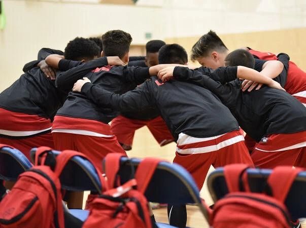 Youth basketball team huddling before a game.