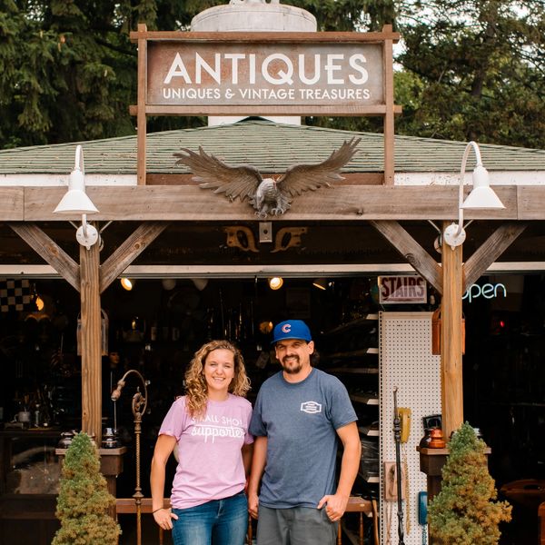 Owners, Ben Jr. and Heather in front of the garage filled with vintage tools, automobilia, and more. 